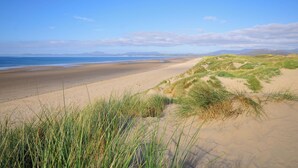 Une plage avec des dunes de sable et un ciel dégagé.