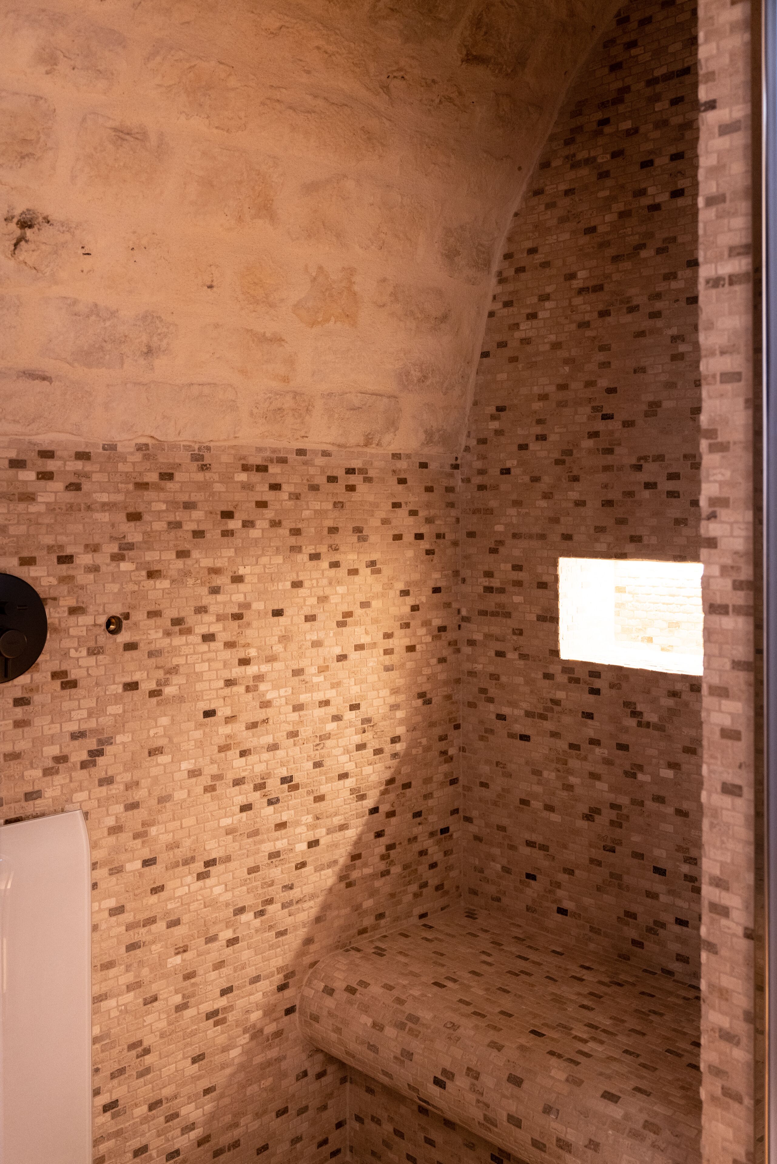 Una habitación con pared de ladrillo, un radiador blanco y un ventanal con vistas.