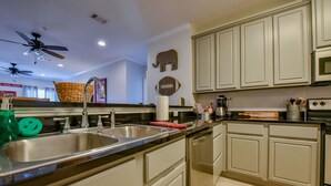 A modern kitchen with a large island, stainless steel appliances, and light-colored cabinetry. - Welcome to Tusk-Away! (Tuscaloosa)