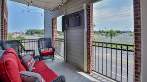 A covered porch with wicker furniture and a TV screen. - Welcome to Tusk-Away! (Tuscaloosa)