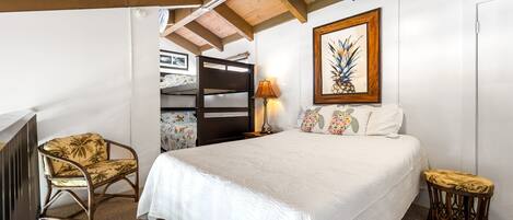 Ein Schlafzimmer mit einem großen Bett, einer Holzbalkendecke, einer Wandlampe und einem gerahmten Bild.