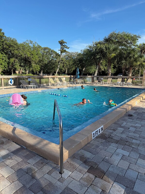 A swimming pool with a wooden deck, lounge chairs, and a lifebuoy. - One block to Beach! Clean, Bright, newly renovated 3BR 2BA Flat (Fernandina Beach)