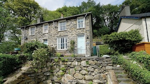Une maison en pierre avec un escalier en pierre menant à l’entrée.
