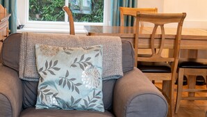 Un salon confortable avec un canapé, une chaise en bois et une table.