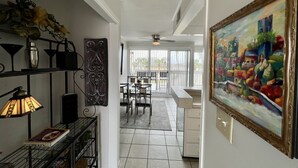 Une cuisine moderne avec un coin repas, un ventilateur de plafond et une grande fenêtre qui laisse entrer la lumière naturelle.