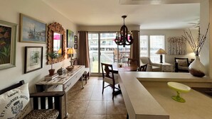 A dining area with a table, chairs, a bench, and a vase with branches. - Relaxing 1BR Canal Retreat w/ Beach Access (Destin)