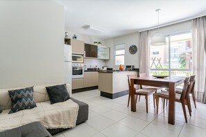 Une cuisine moderne avec un coin repas, un canapé et une vue sur l’extérieur.