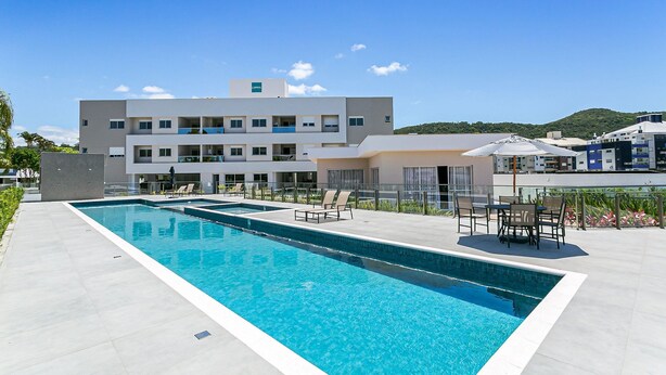 Un hôtel moderne doté d’une piscine, d’un espace extérieur aménagé et offrant une vue sur une colline.