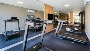 A modern gym with treadmills, an elliptical, and a stationary bike.