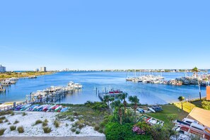A marina with boats docked, a clear blue sky, and a distant bridge. - 🏝️Beach Views-Walk2Beach-Pool-2BR South Harbour 4E (Pensacola Beach)