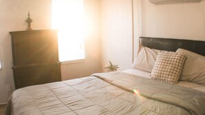 Une chambre à coucher avec un lit, une commode et une fenêtre.