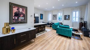 Una sala moderna con un sofá color turquesa, una zona de cocina y un comedor.