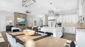 A modern kitchen with white cabinetry, a built-in oven, and a large island with a sink. - Modern Luxury! Sleeps 24! Pool, Spa, Golf, Arcade, Dock! Deep Cove, Calm Waters! (Sunrise Beach)