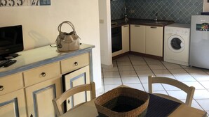 Cucina con lavatrice, lavandino e pensili.