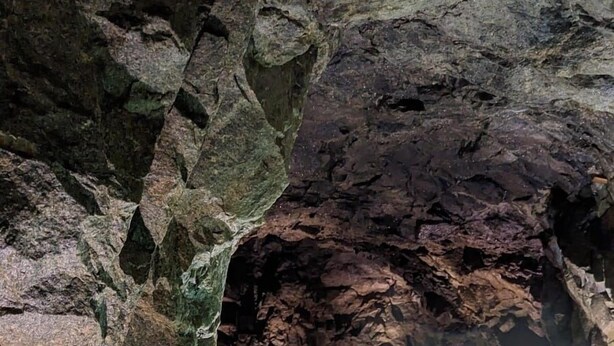 Una formazione rocciosa naturale con una pozza di acqua cristallina.