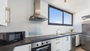 Une cuisine moderne équipée d’un four à micro-ondes, d’une cuisinière, d’un évier et d’un lave-vaisselle.