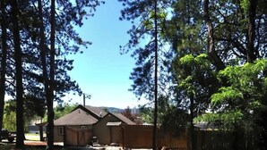 A residential property with a house, a yard, and surrounding trees. - 2BR Cabin • 5 Min to Autzen • Park Access • Pet Friendly (Springfield)