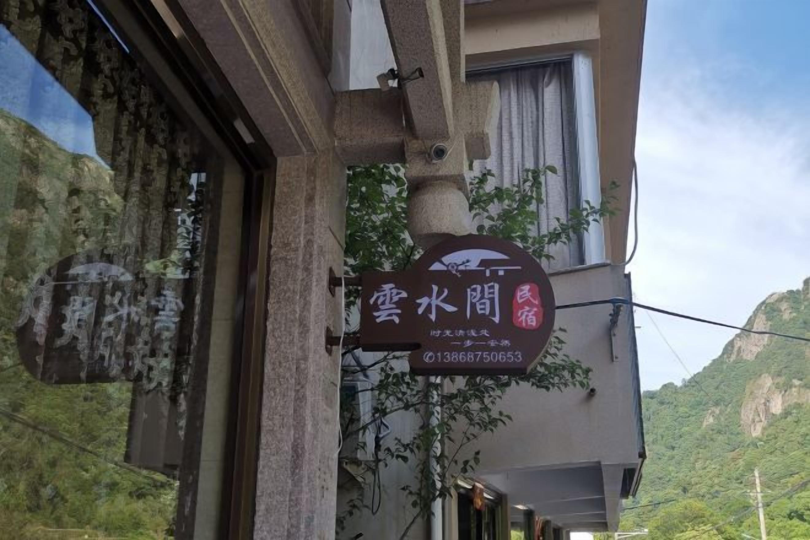Ein Hotelschild mit Blick auf eine Berglandschaft im Hintergrund.
