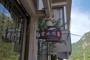 Placa de hotel com vista para montanhas ao fundo.