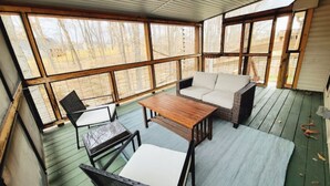 A covered patio area with a sofa, chairs, and a table. - Southern Belle (Clarksville)