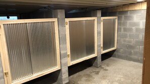A row of enclosed restrooms with metal grilles and concrete pillars. - Entire Campground - All 10 Cabins for Events and Overnights. Up to 40 Guests. (Hatfield)