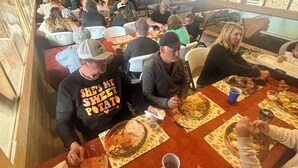 A restaurant with wooden walls, tables with floral tablecloths, and an American flag. - Entire Campground - All 10 Cabins for Events and Overnights. Up to 40 Guests. (Hatfield)