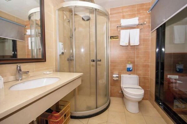A bathroom with a glass-enclosed shower, a sink, and a toilet. - Yuhuangge Hotel (Badong)