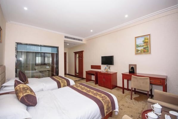 A hotel room with two beds, a desk, a TV, and a painting on the wall. - Yuhuangge Hotel (Badong)