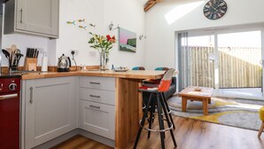 A modern kitchen with a wooden island, white cabinets, and a dining area with a wooden table and chairs.