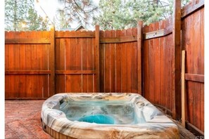 Relax in the backyard hot tub, surrounded by a fence.