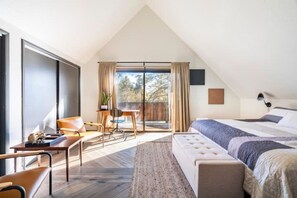 Relax in a spacious bedroom with a large bed, seating area, and expansive outdoor views.
