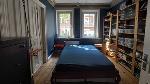 A room with a bed, a dresser, a radiator, and a window with a view of buildings outside. - Family Friendly Funhouse Centrally Located in Ottensen (Hamburg)