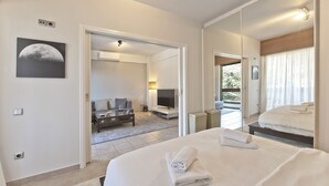 Una habitación de hotel con cama, sofá, televisión y balcón con vistas.