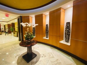 Enter a stylish lobby with a curved floor, a central table, and decorative wall art.
