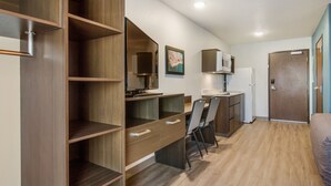 Una cocina compacta con armarios de madera, un microondas y un refrigerador.
