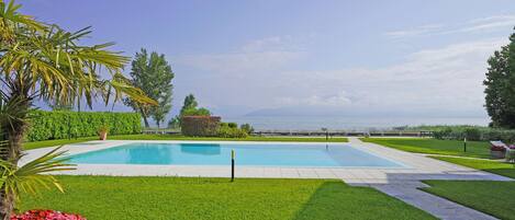 Relax by the serene pool surrounded by lush gardens and a stunning sea view.