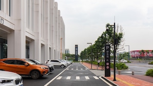 A parking area with multiple cars parked in front of a modern building. - Foshan Laide Apartment (Foshan)