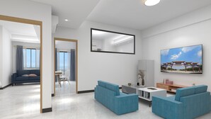 A modern living room with a sofa set, a coffee table, and a TV mounted on the wall. - Foshan Laide Apartment (Foshan)