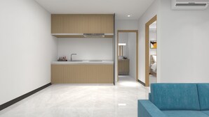 A modern kitchen with wooden cabinets, a sink, and a countertop. There is a blue sofa in the foreground. - Foshan Laide Apartment (Foshan)