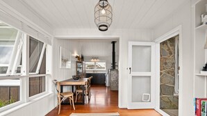 Una cocina moderna con armarios blancos, una mesa de comedor de madera y un tapete a rayas negro y blanco.
