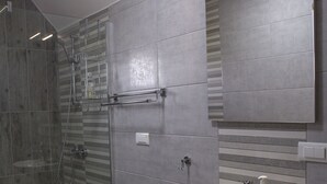 A modern bathroom with a glass-enclosed shower, a white sink, and a mirror above it. - Rocky Mountain Triple Room (Prisoje)