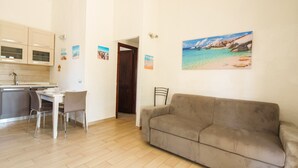 A compact living space with a kitchenette, a dining area, and a sofa. - MareSole La Cinta - Two Bedroom Apartment, Sleeps 6 (San Teodoro)