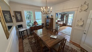 A dining area with a wooden table, chairs, a chandelier, and a view of the outdoors. - Old Town Charmer Large all new renovation, walk to USM, Zoo and new Water Park! (Hattiesburg)