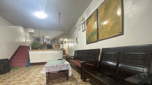A hotel lobby with a reception desk, a staircase, a patterned floor, and a seating area with benches. - WAYU HOUSE (Dawu)