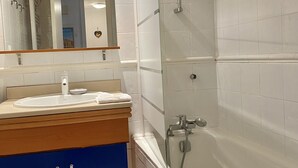 Une salle de bain avec un lavabo, un miroir et une douche.