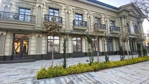 A large, classical building with a symmetrical facade, multiple windows, and a central entrance. - WELLFORT HOTEL (Samarkand)