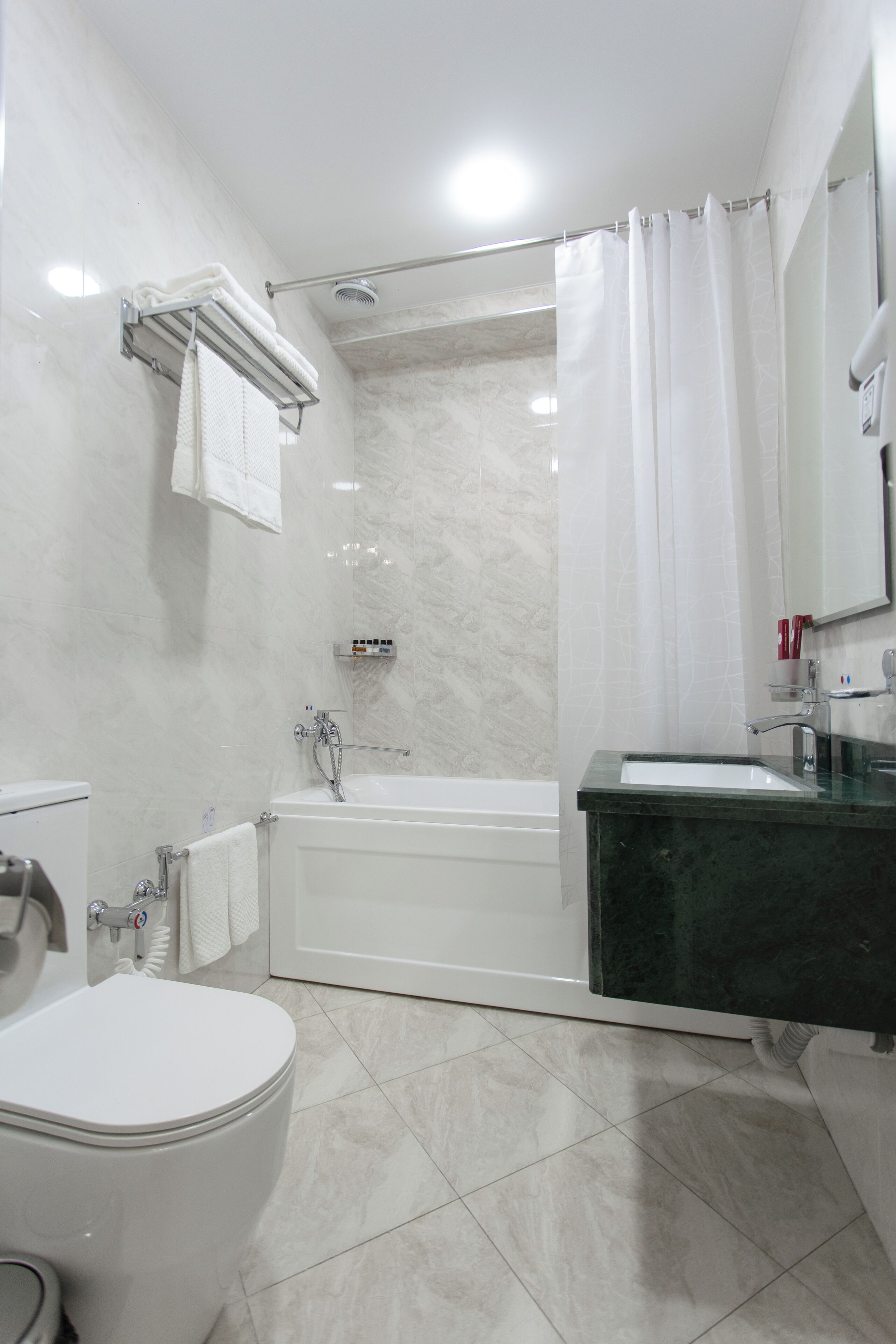 Une salle de bain moderne équipée de toilettes, d’une baignoire et d’un lavabo.