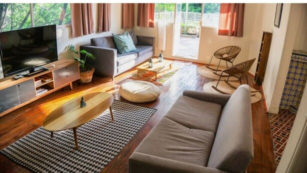 Un salon moderne avec un canapé, un téléviseur et une table basse.