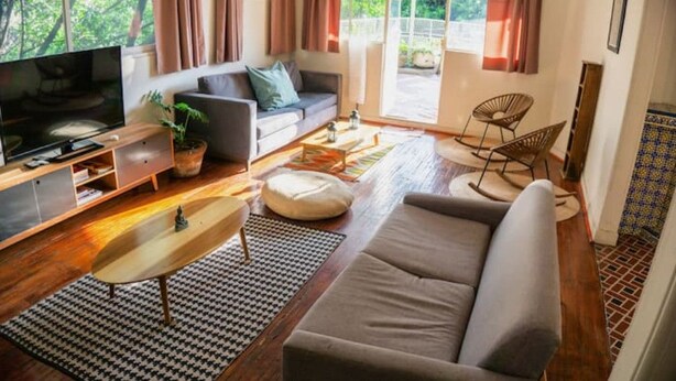 Una sala de estar moderna con un sofá, televisión y una mesa de centro.