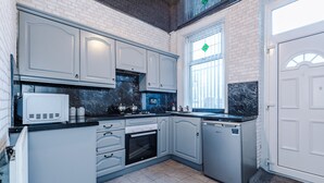 A modern kitchen with white cabinetry, a built-in oven, and a microwave.